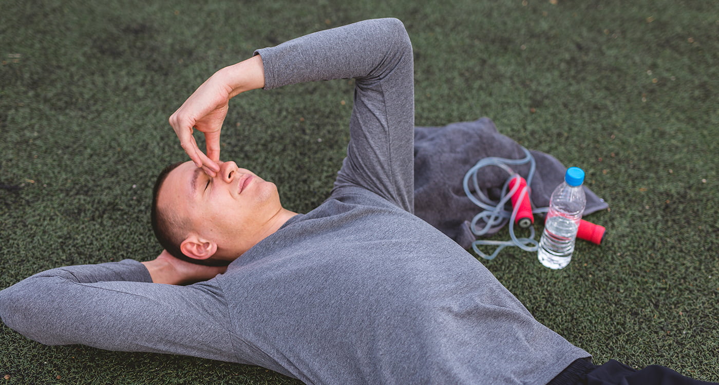 a man at lying in the grass looking distressed